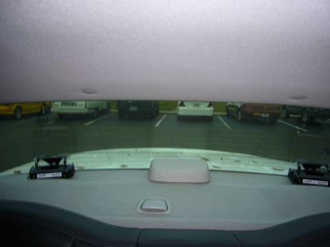 2000 Ford Crown Victoria - View from inside a vehicle's rear window shows a parking lot with several cars and a radar detector on the rear deck.