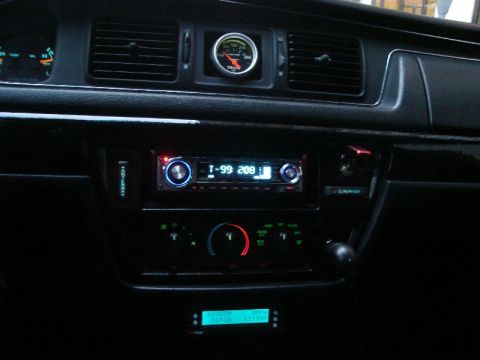 1992 Ford Crown Victoria - Interior view of a car's dashboard an aftermarket stereo and a gauge.