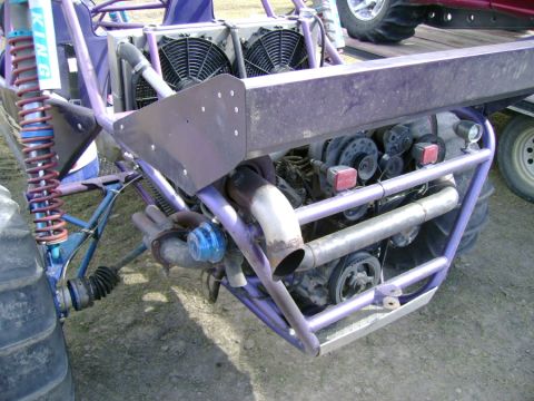 1994 Mazda MX-3 - The rear engine and suspension of a custom purple dune buggy are visible.