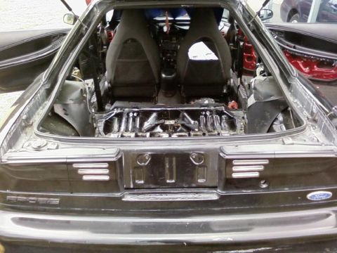 1993 Ford Probe - Interior view of a black car with seats removed, revealing the chassis and engine bay.