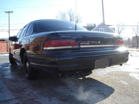 1992 Ford Crown Victoria - Rear view of a dark sedan, likely a Ford Crown Victoria, with exhaust visible.