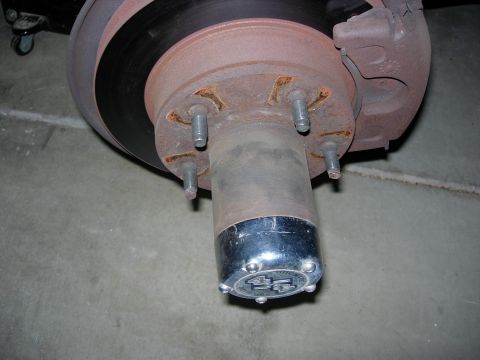 1990 Ford Bronco - A close-up view of a vehicle's brake rotor and hub assembly, showing signs of rust and wear.