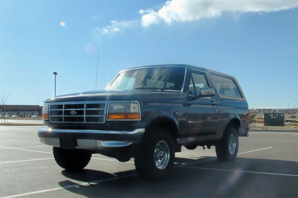 Dark blue Ford Bronco parked in a lot, front quarter view