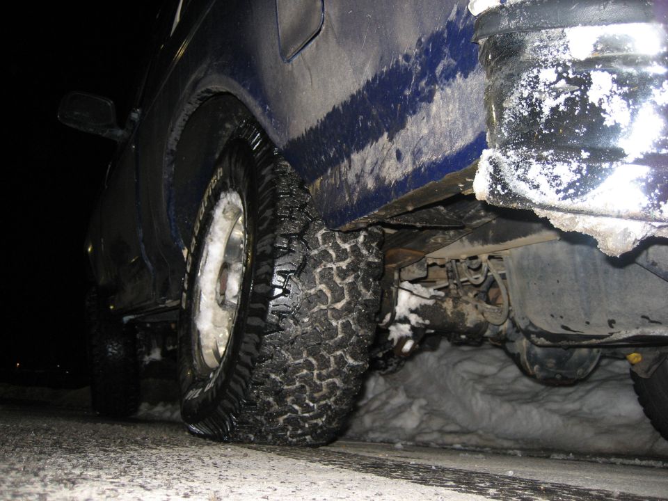 1993 Ford Bronco side view, blue, with snow on tires and ground