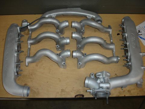 1992 Ford Taurus - Silver Ford intake manifold and runner components are arranged on a workbench.