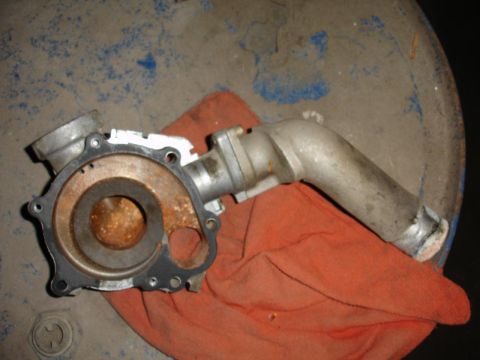 1992 Ford Taurus - A used water pump, showing signs of wear and corrosion, is placed on a rag.