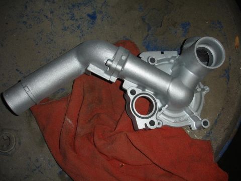 1992 Ford Taurus - A silver water pump is shown resting on a red cloth, with some text visible on its surface.