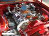 1989 Ford Bronco - Detailed view of a chrome engine installed in a red vehicle, likely a custom build.