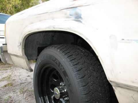 1985 Ford LTD Crown Victoria - Close-up of a vehicle's front wheel well and fender, indicating bodywork in progress.