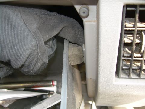 1988 Ford Bronco - A hand wearing a glove is shown reaching into a vehicle's interior compartment, near an air vent.