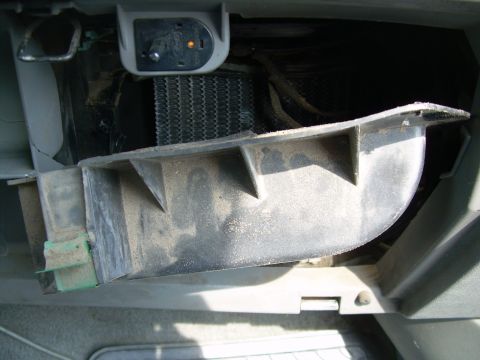 1988 Ford Bronco - Close-up view of a dusty heater core assembly and surrounding ductwork within a vehicle's interior.