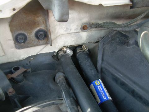 1988 Ford Bronco - Close-up of heater hoses connected to a housing, likely part of a vehicle's HVAC system.