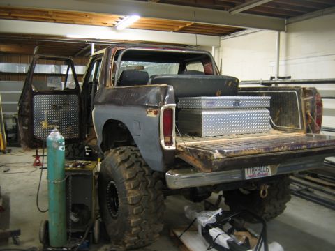 1992 Ford Mustang - A heavily modified pickup truck is shown in a workshop with its doors and tailgate open, revealing a toolbox in the bed.