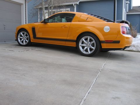 2007 Saleen S-302 - This orange 2007 Saleen S-302 Mustang is parked in front of a garage.