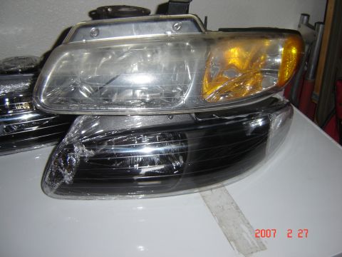 1997 Dodge Grand Caravan - Pair of aftermarket headlights, one clear and one with black housing, are shown.