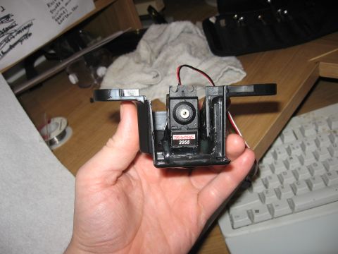 1990 Ford Bronco - A hand holds a disassembled electronic component, revealing internal wiring and a small motor.