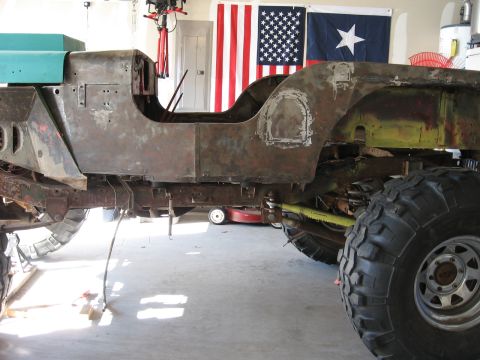 1986 Ford Bronco - This heavily rusted Jeep CJ-5 body and frame, equipped with large off-road tires, is in a state of restoration.