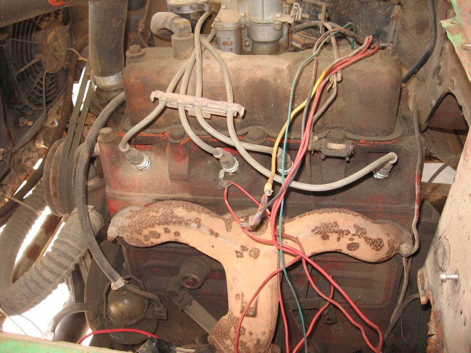 Close-up of a V8 engine with spark plug wires and exhaust manifold