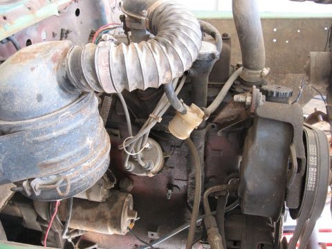 1986 Ford Bronco - Close-up view of engine components, including hoses and electrical wiring, in a vehicle's engine bay.