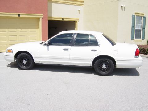 2000 Ford Crown Victoria - Side profile of a white 2000 Ford Crown Victoria, showing its clean body lines and black steel wheels.