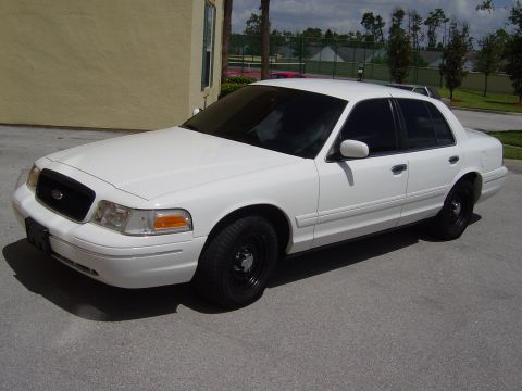 2000 Ford Crown Victoria - A white 2000 Ford Crown Victoria sedan is parked outdoors on an asphalt surface, viewed from the front three-quarter angle.