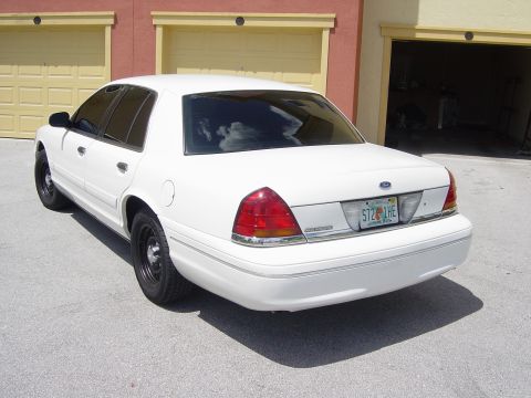 2000 Ford Crown Victoria - Rear 3/4 view of a white 2000 Ford Crown Victoria parked in front of a garage.
