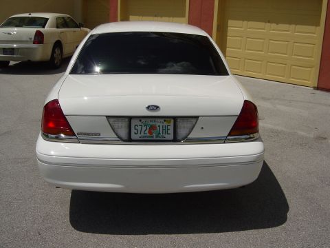2000 Ford Crown Victoria - Rear view of a white 2000 Ford Crown Victoria parked next to another car.