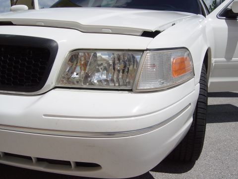 2000 Ford Crown Victoria - Front corner view of a white 2000 Ford Crown Victoria, showing the headlight and grille.