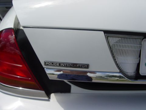 2000 Ford Crown Victoria - Close-up of the "POLICE INTERCEPTOR" badge on the rear of a white vehicle.