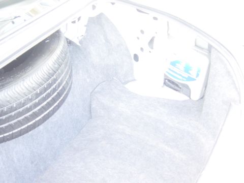 2000 Ford Crown Victoria - The trunk of a vehicle contains a spare tire and a roadside emergency kit with visible text.
