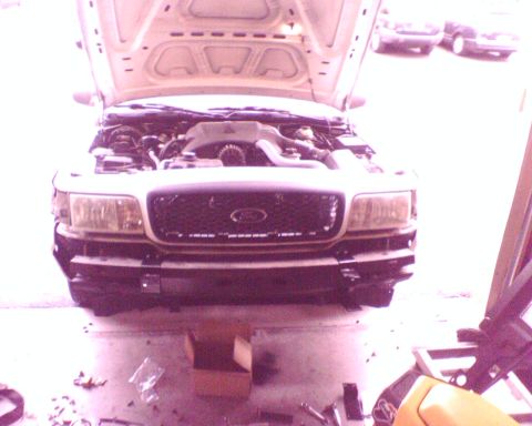 2000 Ford Crown Victoria - Front view of a white 2000 Ford Crown Victoria with its hood open, revealing the engine compartment.