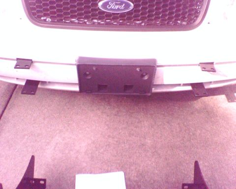 2000 Ford Crown Victoria - Close-up of the front grille and bumper assembly of a Ford vehicle, with mounting brackets visible.