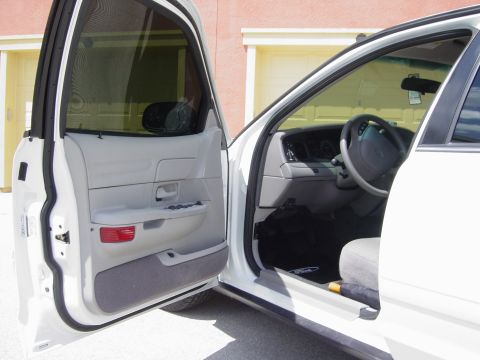 2000 Ford Crown Victoria - The interior of a white Ford Crown Victoria, viewed from the driver's side with the door open.