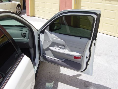 2000 Ford Crown Victoria - Interior view of a white 2000 Ford Crown Victoria, showing the door panel and dashboard.
