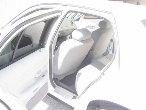 2000 Ford Crown Victoria - The interior of a white 2000 Ford Crown Victoria is visible with the driver's door open.