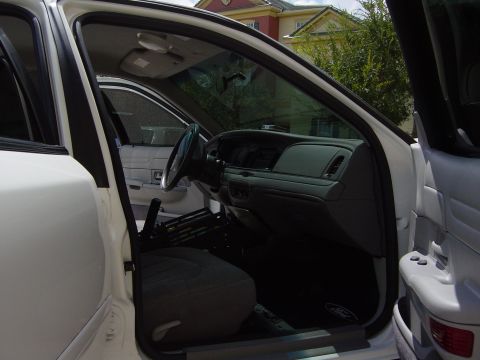 2000 Ford Crown Victoria - Interior view of a white Ford Crown Victoria, showing the dashboard, steering wheel, and front seats.