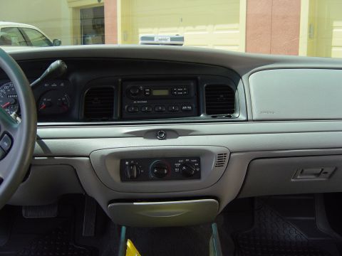 2000 Ford Crown Victoria - The dashboard of a 2000 Ford Crown Victoria, the instrument cluster, radio, and HVAC controls.
