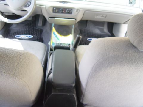 2000 Ford Crown Victoria - The interior of a 2000 Ford Crown Victoria, floor mats with the Ford logo and a view of the dashboard and center console.