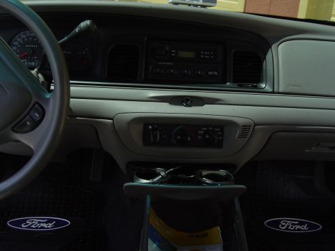2000 Ford Crown Victoria - Interior view of a 2000 Ford Crown Victoria, showing the dashboard, steering wheel, and floor mats with Ford branding.