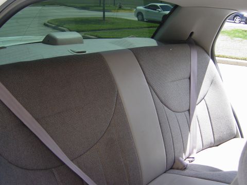 2000 Ford Crown Victoria - View from the back seat shows the interior and a glimpse of the exterior through the tinted rear window.