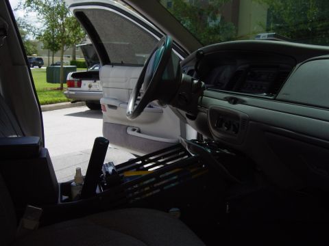 2000 Ford Crown Victoria - The interior of a 2000 Ford Crown Victoria is viewed from the passenger side, revealing the dashboard and steering wheel.