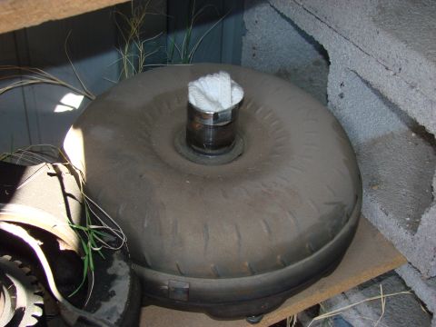 1979 Ford Bronco - A torque converter, likely for a Ford vehicle, is shown with a white cloth stuffed into its input shaft opening.
