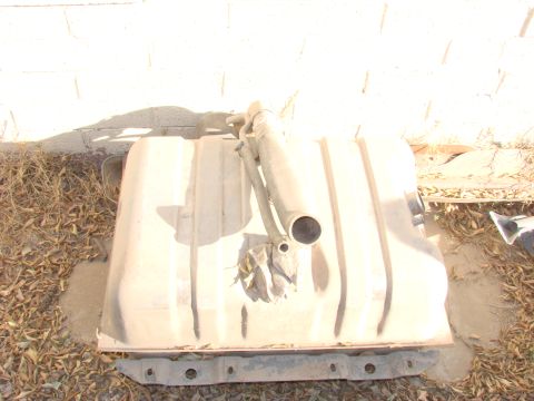 1979 Ford Bronco - A tan fuel tank with attached metal straps and filler neck is shown resting on the ground.