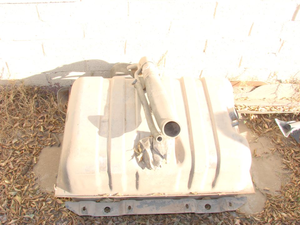 Tan fuel tank with metal straps and filler neck, resting on the ground