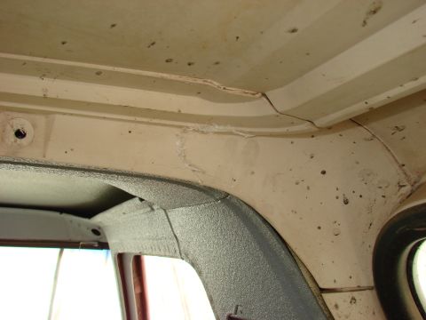 1979 Ford Bronco - Close-up of the interior ceiling and window frame, revealing wear and tear on the headliner.