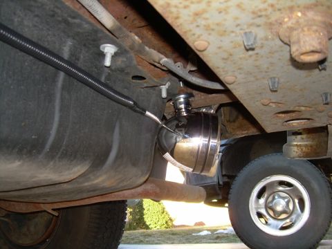 1988 Ford Bronco - An aftermarket reverse light is visible mounted beneath the vehicle's frame, close to the fuel tank and exhaust pipe.