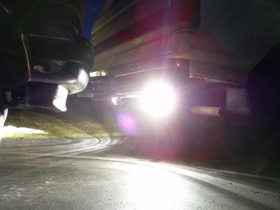 vehicle exhaust pipe with bright reverse lights illuminating the ground