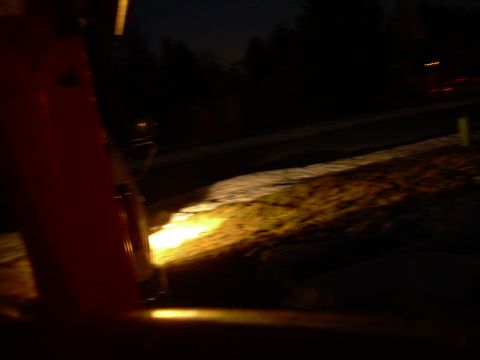 1988 Ford Bronco - A close-up view of a red vehicle part, possibly a fender or door, illuminated by headlights in the dark.