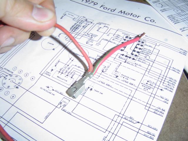 Red wire and connector held over a 1979 Ford Motor Co. wiring diagram