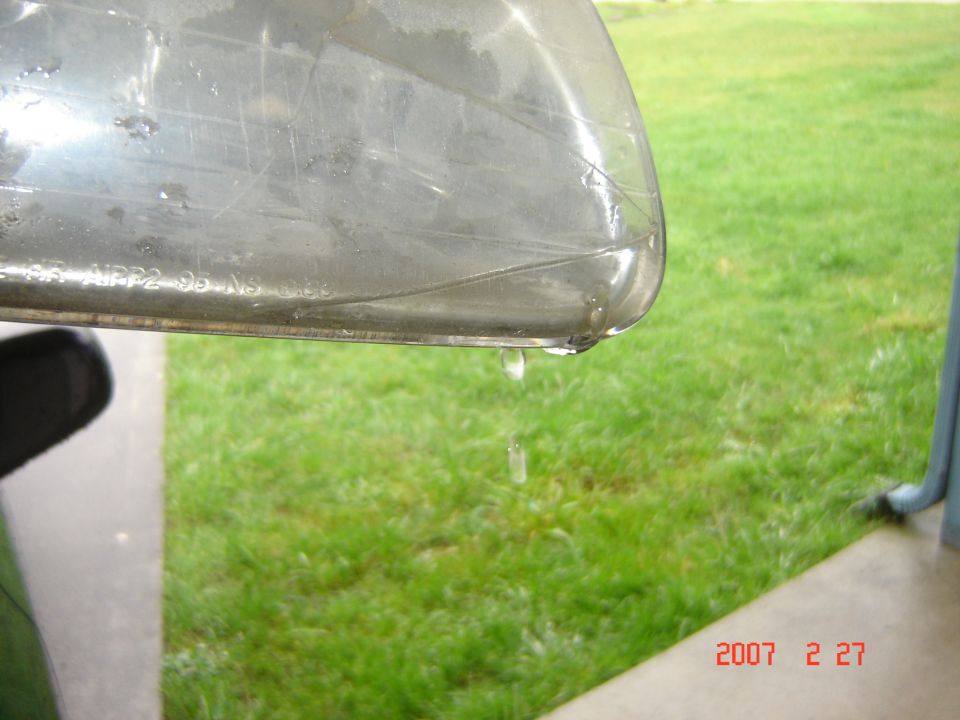 Headlight with visible cracks and water dripping, showing text 'MPP2 96 AS'